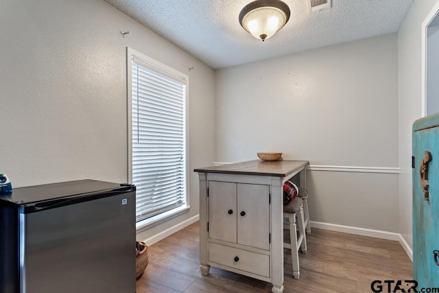 interior space with a healthy amount of sunlight, light hardwood / wood-style floors, and a textured ceiling