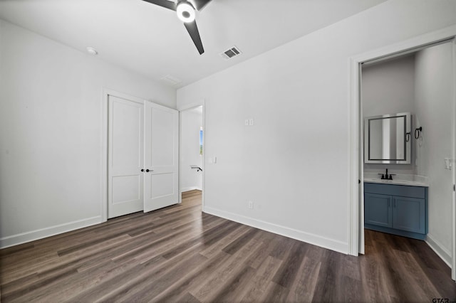 unfurnished bedroom with ceiling fan, ensuite bath, sink, and dark hardwood / wood-style flooring