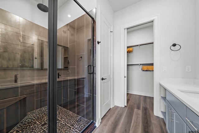 bathroom featuring an enclosed shower, wood-type flooring, and vanity