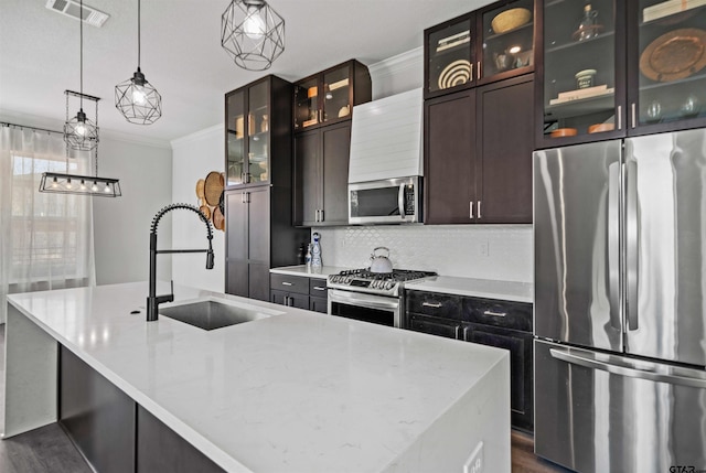 kitchen with crown molding, stainless steel appliances, pendant lighting, sink, and dark wood-type flooring