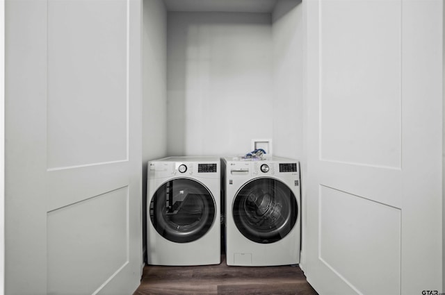 clothes washing area with dark wood-type flooring and washer and dryer