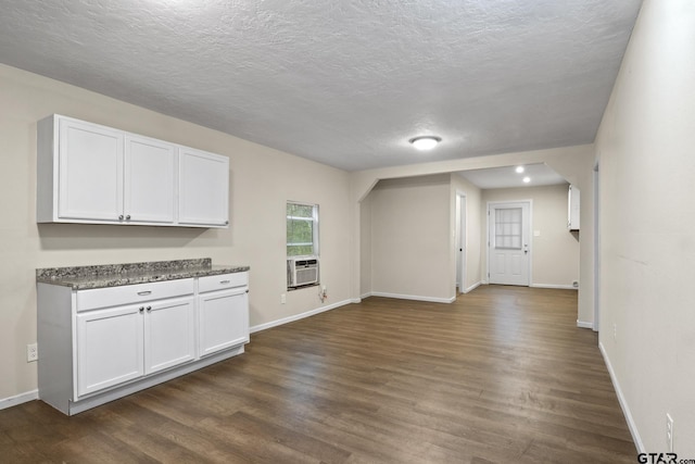 kitchen with a textured ceiling, dark hardwood / wood-style floors, and white cabinets