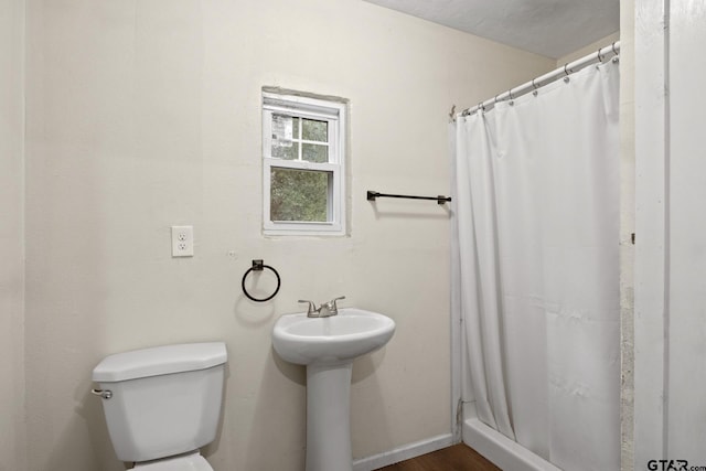 bathroom featuring a shower with curtain and toilet