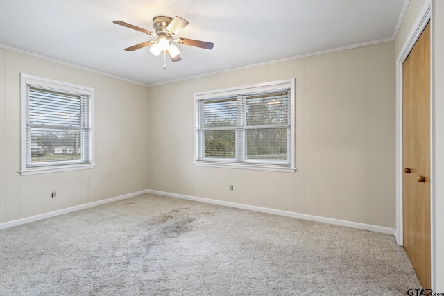 spare room with ornamental molding, carpet flooring, and ceiling fan