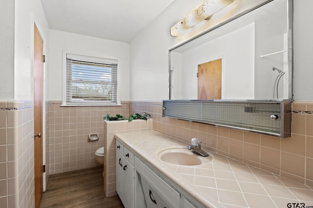 bathroom with hardwood / wood-style flooring, vanity, tile walls, and toilet