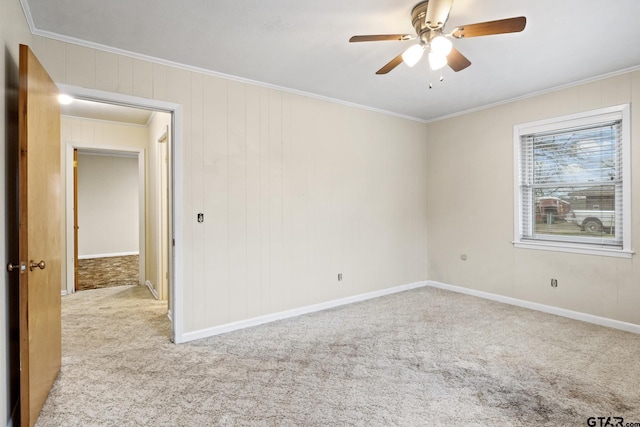 carpeted empty room featuring crown molding and ceiling fan