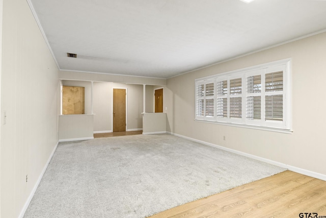 empty room with ornamental molding and hardwood / wood-style floors