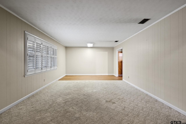 unfurnished room featuring crown molding, light colored carpet, and a textured ceiling