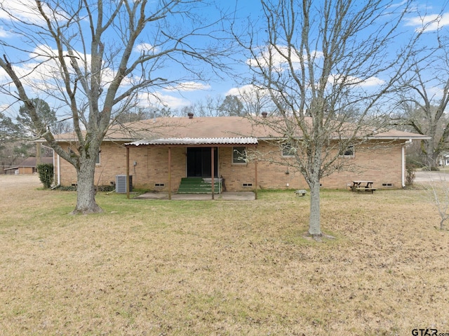 rear view of house featuring cooling unit, a lawn, and a patio