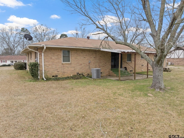 rear view of property featuring central AC unit, a lawn, and a patio