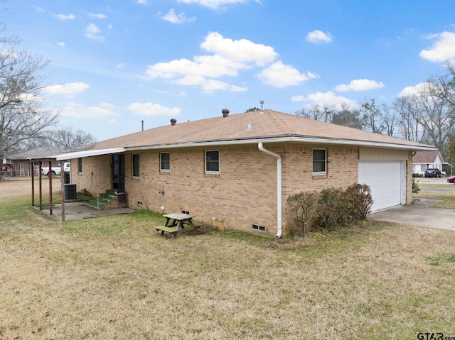 back of property featuring a garage, a yard, and cooling unit