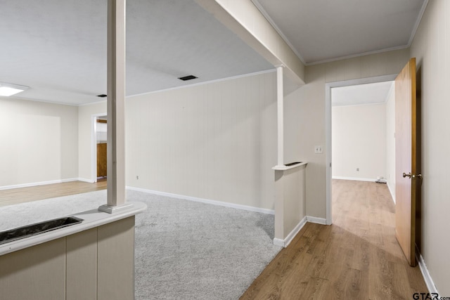 hall with ornamental molding and light hardwood / wood-style flooring