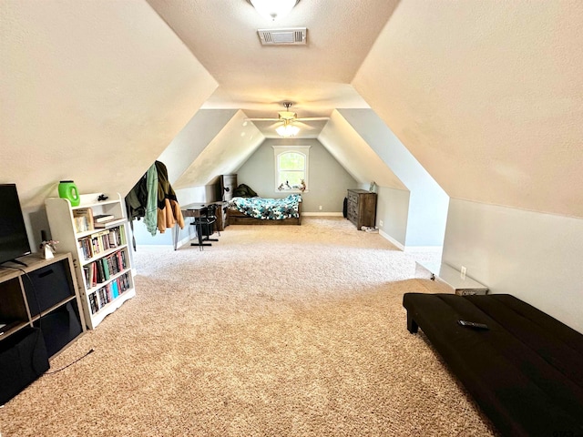 bedroom featuring carpet, a textured ceiling, and lofted ceiling