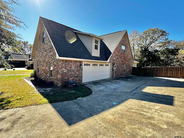 view of side of property featuring a garage and a yard