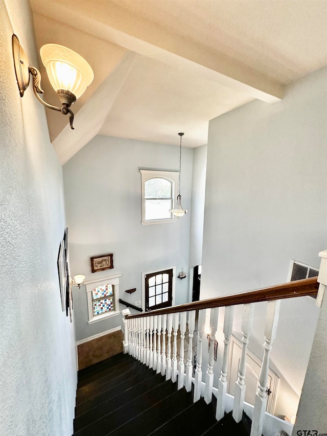 stairway with hardwood / wood-style floors and lofted ceiling