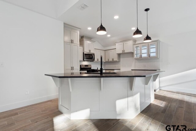 16234 Crossing Cir, Lindale, TX 75771 - kitchen featuring baseboards, a sink, dark countertops, light wood finished floors, and stainless steel appliances