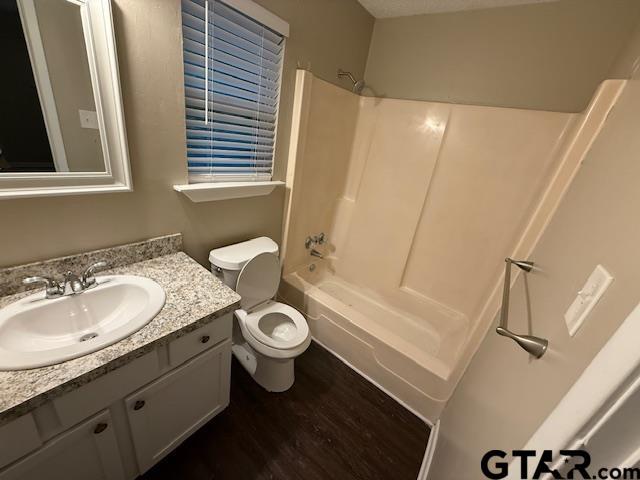 2523 Westminster Dr, Tyler, TX 75701 - full bathroom featuring vanity, washtub / shower combination, and wood finished floors