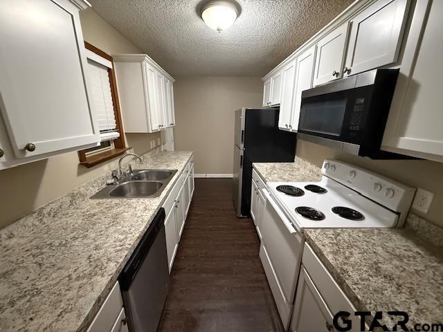 2523 Westminster Dr, Tyler, TX 75701 - kitchen with stainless steel appliances, dark wood-style flooring, a textured ceiling, white cabinets, and light countertops