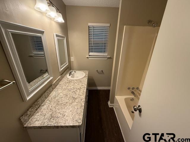 2523 Westminster Dr, Tyler, TX 75701 - full bathroom with vanity, wood finished floors, and shower / bathtub combination