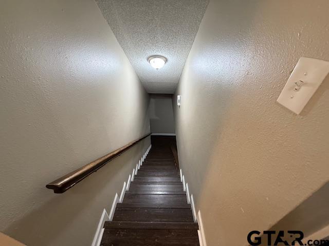 2523 Westminster Dr, Tyler, TX 75701 - staircase featuring wood finished floors and a textured ceiling