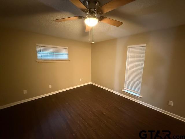 2523 Westminster Dr, Tyler, TX 75701 - spare room featuring dark wood-type flooring, ceiling fan, and a textured ceiling