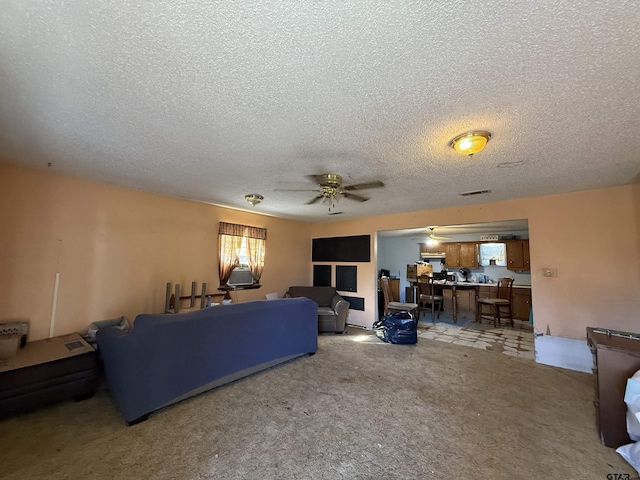 living room with ceiling fan and a textured ceiling