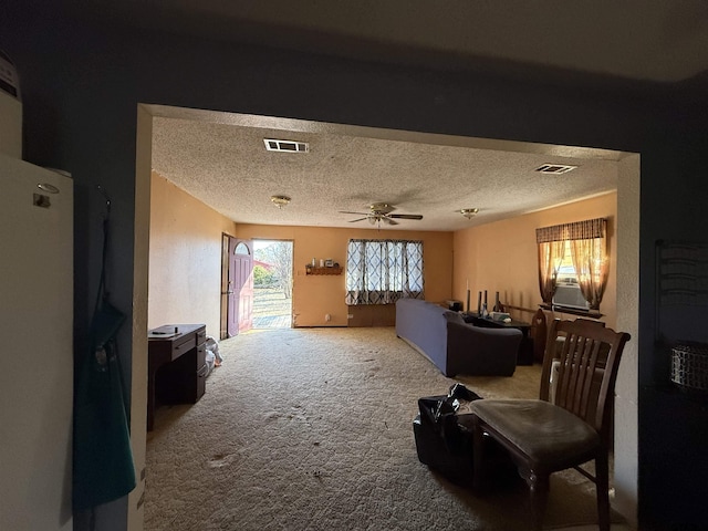 interior space featuring a textured ceiling, carpet flooring, and ceiling fan