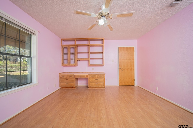 unfurnished office with ceiling fan, a textured ceiling, and light wood-type flooring