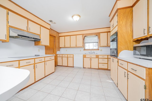 kitchen with black appliances, light tile patterned floors, and sink