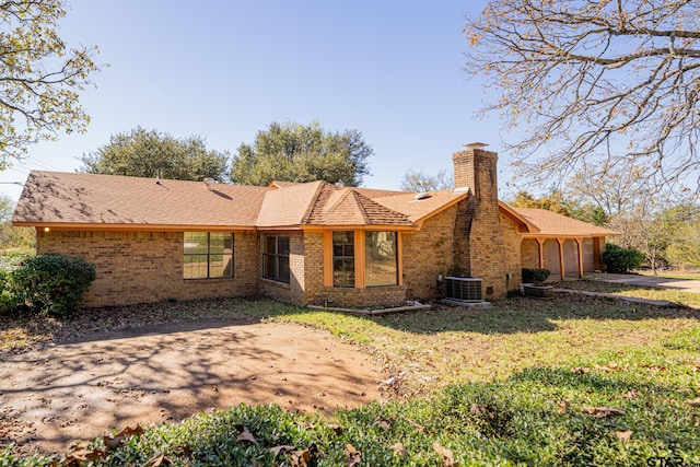 back of property with central AC and a yard