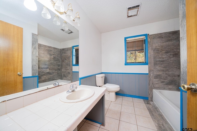 bathroom featuring tile patterned floors, a washtub, a textured ceiling, and toilet