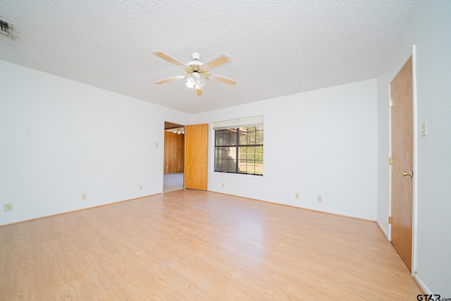 spare room with ceiling fan, light wood-type flooring, and a textured ceiling