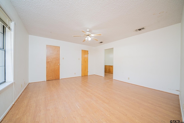 unfurnished room with a textured ceiling, light hardwood / wood-style flooring, and ceiling fan