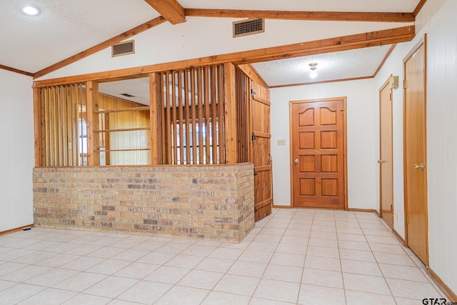 entryway featuring wood walls, light tile patterned floors, lofted ceiling with beams, and a textured ceiling