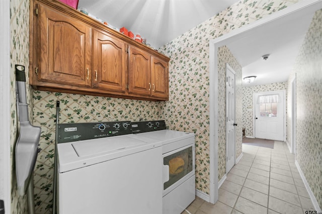 laundry area with independent washer and dryer and light tile patterned floors