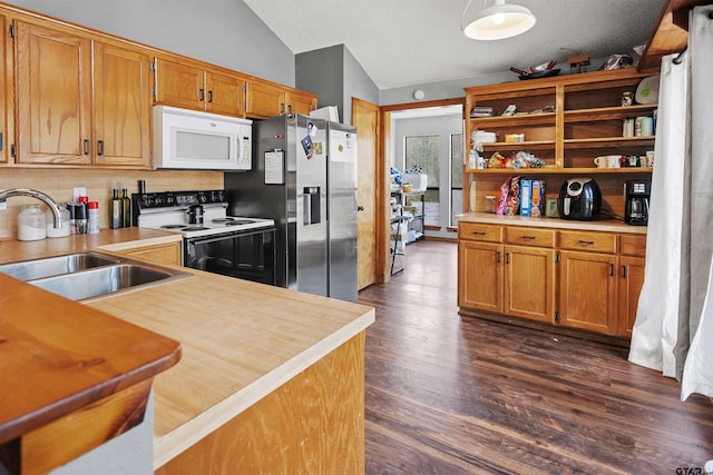 kitchen featuring range with electric stovetop, lofted ceiling, white microwave, a sink, and stainless steel fridge with ice dispenser