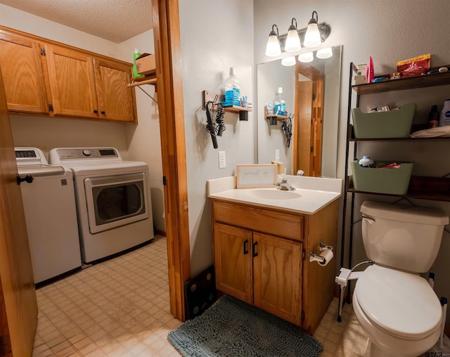 interior space featuring separate washer and dryer, vanity, toilet, and tile patterned floors