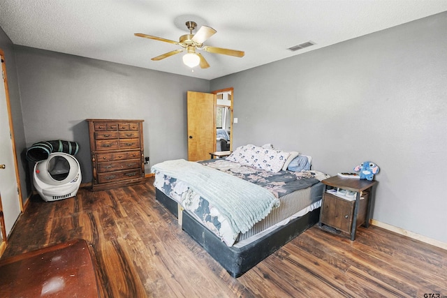 bedroom featuring baseboards, visible vents, ceiling fan, and wood finished floors