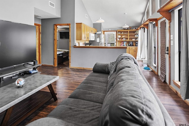 living area featuring dark wood-type flooring, visible vents, high vaulted ceiling, and baseboards