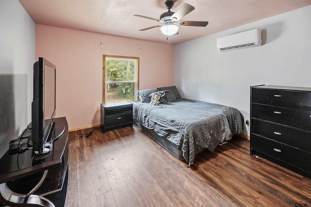 bedroom with ceiling fan, a wall unit AC, hardwood / wood-style flooring, and baseboards