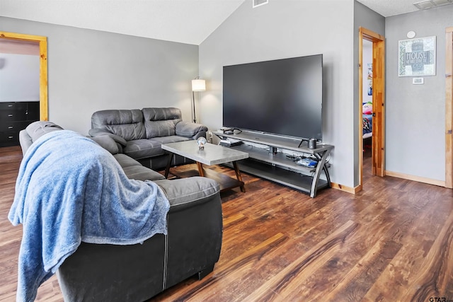 living room with lofted ceiling, visible vents, baseboards, and wood finished floors