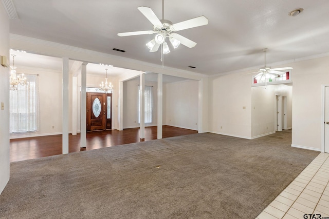 entryway with ceiling fan with notable chandelier, crown molding, and dark carpet