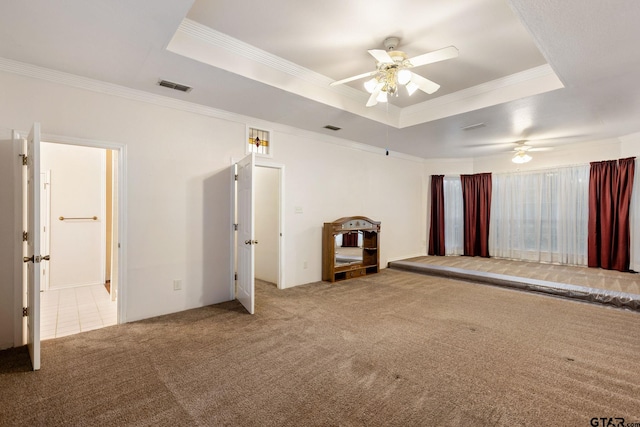 unfurnished bedroom with ceiling fan, crown molding, carpet, and a tray ceiling