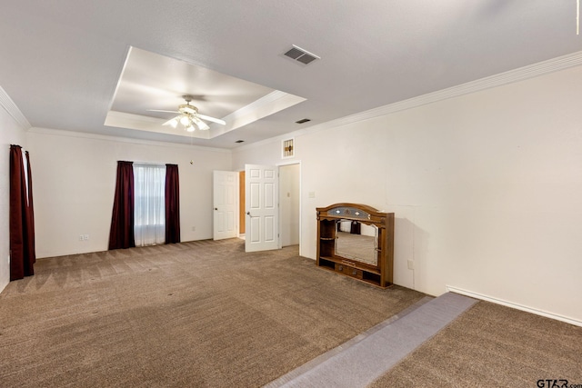 empty room featuring ceiling fan, ornamental molding, a raised ceiling, and carpet