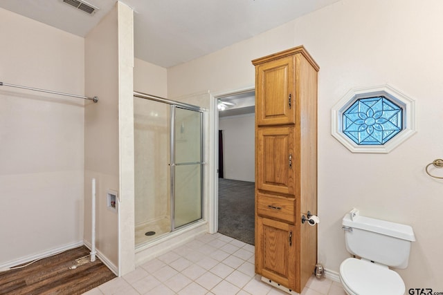 bathroom featuring walk in shower, hardwood / wood-style floors, and toilet