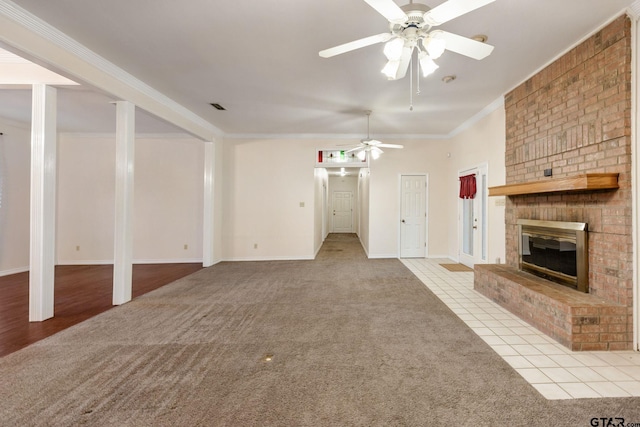 unfurnished living room with a fireplace, light tile patterned flooring, ceiling fan, and crown molding