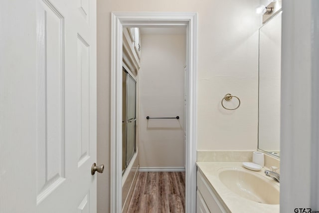 bathroom featuring walk in shower, vanity, and hardwood / wood-style floors