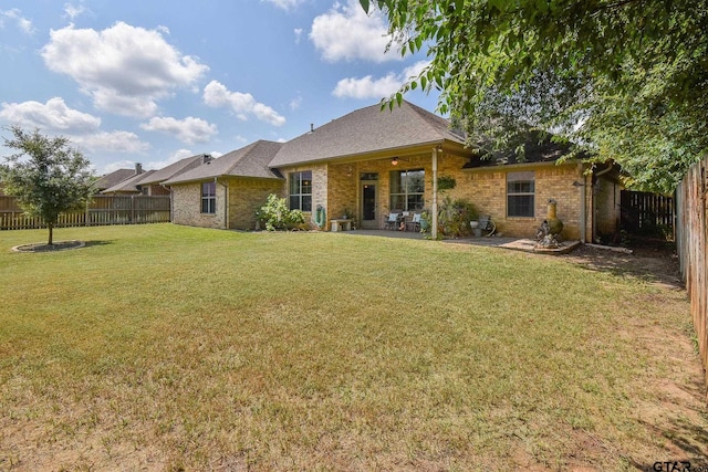 rear view of property with a yard and ceiling fan