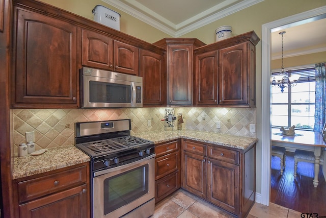 kitchen with appliances with stainless steel finishes, backsplash, light tile patterned floors, and a notable chandelier