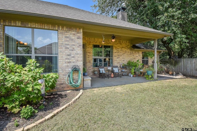 property entrance with a lawn, ceiling fan, and a patio